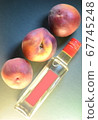three ripe peaches close-up over a bottle with a 67745248