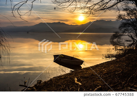 Small fishing boat and sunrise 67745388