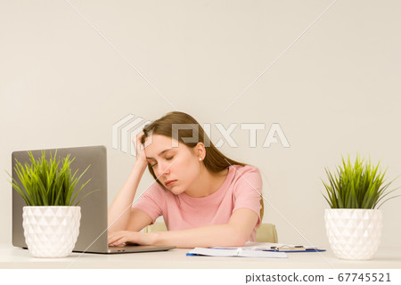 Tired overworked young intern woman working with a Tired overworked young intern woman working with a 67745521
