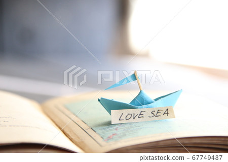Love Sea. Paper boat on the map and inscription. Love Sea. Paper boat on the map and inscription. 67749487