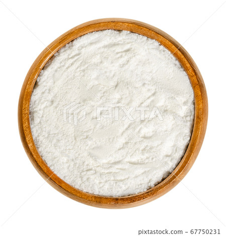 Baking powder in wooden bowl. White, dry chemical leavening agent. Mixture of carbonate or bicarbonate and weak acid. With cornstarch to prevent from reacting prematurely. Close-up, from above, photo. 67750231
