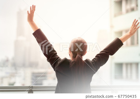 Rear view of a woman with both hands open Rear view of a woman with both hands open 67750435