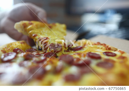 Male hand hold piece of pizza closeup. 67750865