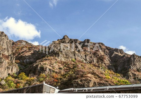 Pigeons in the autumn sun on the background of the Gegham mountains, in the Geghard monastery in Armenia Pigeons in the autumn sun on the background of the Gegham mountains, in the Geghard monastery in Armenia 67753099