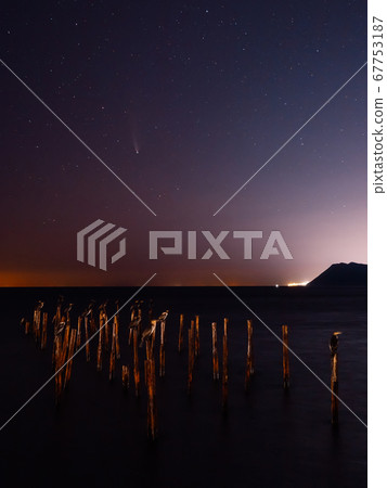 Comet C/2020 NEOWISE at night star sky with sea, birds and city lights 67753187