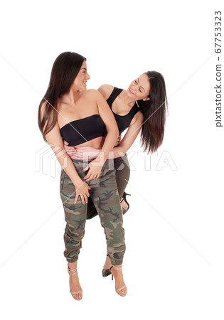 Two lovely woman standing, looking at each other 67753323