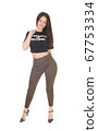 Lovely young woman standing in olive pants and a 67753334