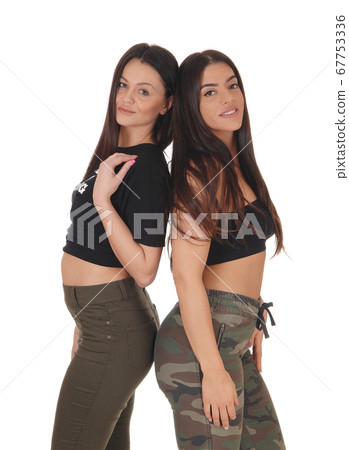 Two lovely woman standing back to back 67753336
