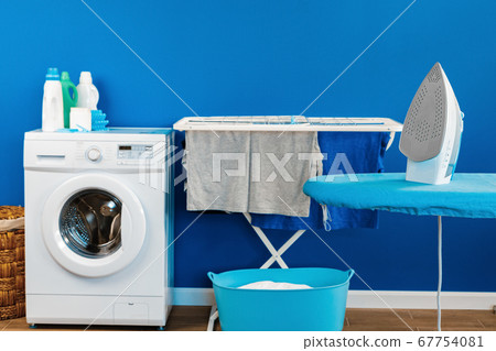 Housekeeping concept. Washing machine and ironing board 67754081