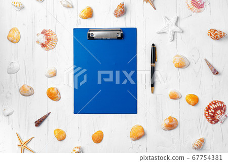 Clipboard with sea shells on wooden table close up, copy space 67754381