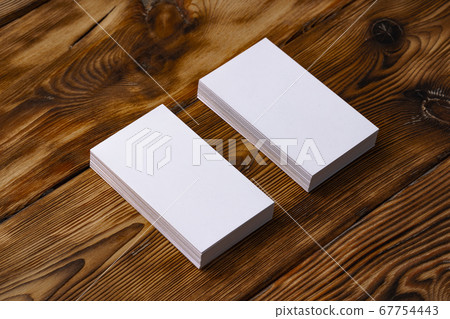 Stack of white business cards on brown wooden background Stack of white business cards on brown wooden background 67754443