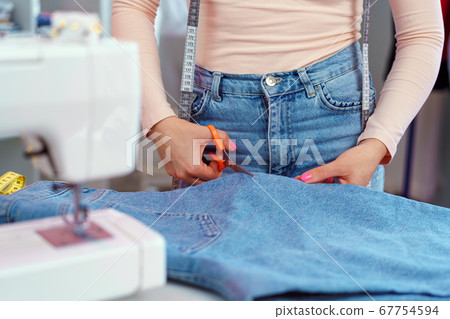 Woman seamstress working at textile factory close up Woman seamstress working at textile factory close up 67754594