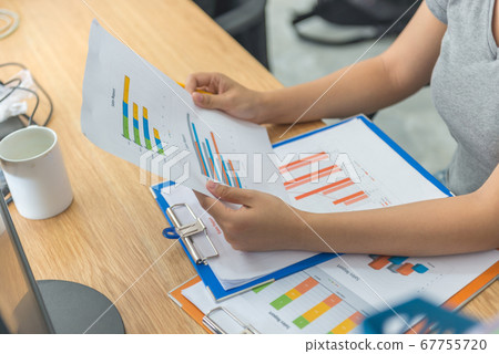 Asian manager checking financial sales reports in her business office 67755720