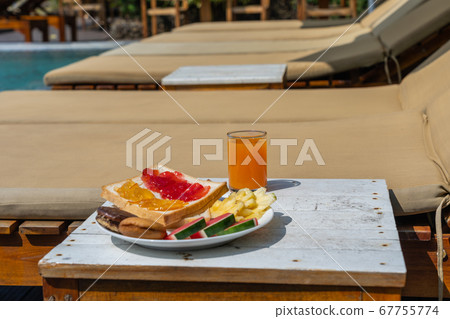 Side view of delicious breakfast at the swimming pool Side view of delicious breakfast at the swimming pool 67755774
