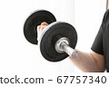 A man doing muscle training in his home room using dumbbells A man doing muscle training in his home room using dumbbells 67757340