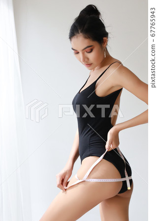 full length healthy and slim woman taking measurements of her body full length healthy and slim woman taking measurements of her body 67765943