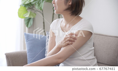 Young woman scratching her arm 67767481