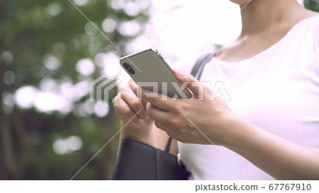 Business woman operating a smartphone Business woman operating a smartphone 67767910