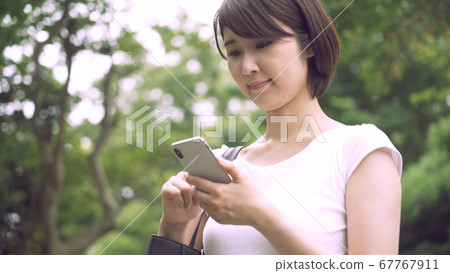 Business woman operating a smartphone Business woman operating a smartphone 67767911
