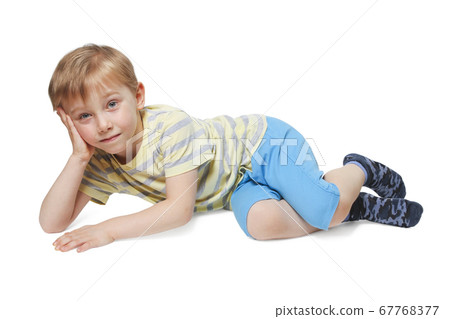 Boy posing while lying down Boy posing while lying down 67768377