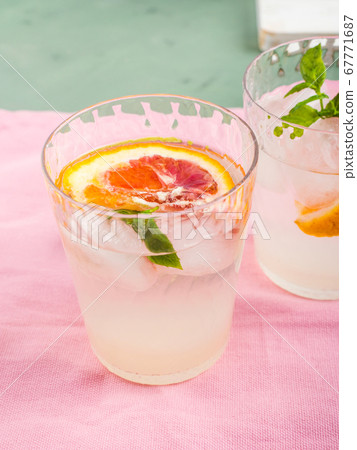 Summer iced citrus drink with mint on pink napkin Summer iced citrus drink with mint on pink napkin 67771687