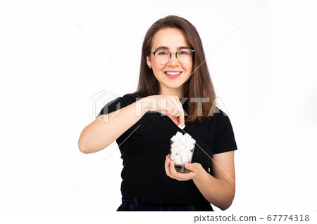 young beautiful woman holding a glass with sugar in her hand 67774318
