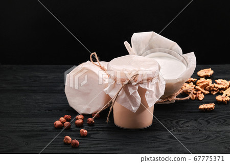 Homemade fermented baked milk in transparent bowl on an old dark background. Rustic. Milk products. Background image, copy space 67775371