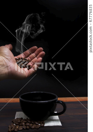 Coffee beans with smoke floating in the hand Coffee beans with smoke floating in the hand 67776835