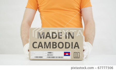 Carton with MADE IN CAMBODIA text being placed on the table 67777306