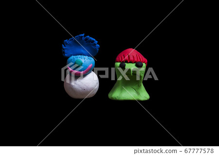 2 pieces of plasticine monster made in Halloween that are isolated from black clay. 67777578