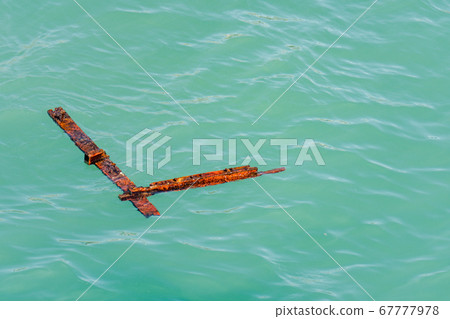Rusty steel debris floating in the sea Rusty steel debris floating in the sea 67777978