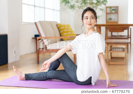 Young woman doing yoga at home Young woman doing yoga at home 67778270