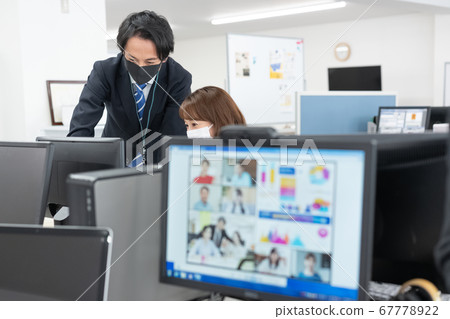 Two office workers wearing masks at the company over the web conference screen Two office workers wearing masks at the company over the web conference screen 67778922