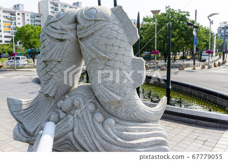 Stone statuary of two fishes kissing each other represent the Pisces in zodiac on the footpath in Gimehae, South Gyeongsang province, South Korea. 67779055