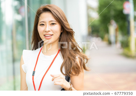 [Business scene] A young office lady with a smiling office district [Summer] 67779350
