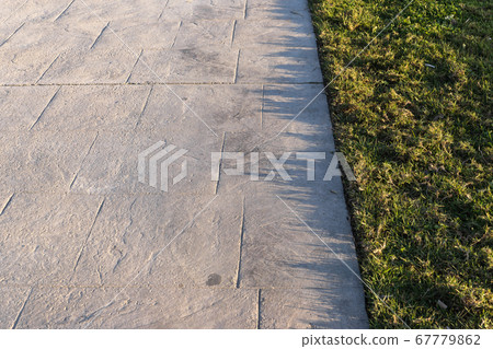 Stamped concrete pavement outdoor with an expansion joint at top, decorative appearance colors and textures of paving slate stone tile on cement Stamped concrete pavement outdoor with an expansion joint at top, decorative appearance colors and textures of paving slate stone tile on cement 67779862