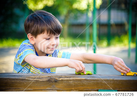 Cute little boy, playing with little toy cars on 67781726