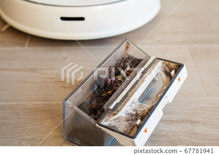 Smart House. Vacuum cleaner robot runs on wood floor in a living room 67781941