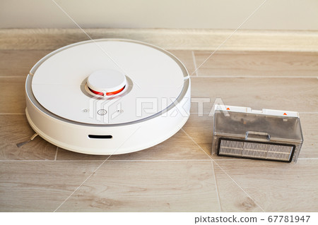 Smart House. Vacuum cleaner robot runs on wood floor in a living room 67781947