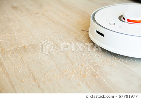 Smart House. Vacuum cleaner robot runs on wood floor in a living room 67781977