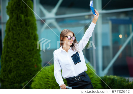 Young Cheerful Woman With a Suitcase. The Concept of Travel and Work Young Cheerful Woman With a Suitcase. The Concept of Travel and Work 67782642