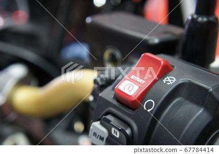 KUALA LUMPUR, MALAYSIA -JULY 25, 2019: Motorcycle ignition and engine kill button. Placed at the right-hand side of the motorcycle handle. It is usually red. KUALA LUMPUR, MALAYSIA -JULY 25, 2019: Motorcycle ignition and engine kill button. Placed at the right-hand side of the motorcycle handle. It is usually red. 67784414