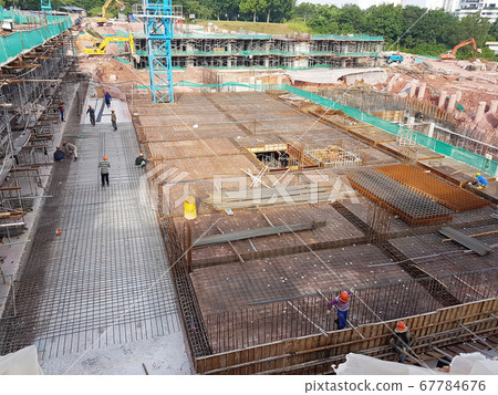 KUALA LUMPUR, MALAYSIA -MARCH 3, 2020: Building floor slab under construction. Construction workers fabricating the timber formwork and installing the steel reinforcement bar.  67784676