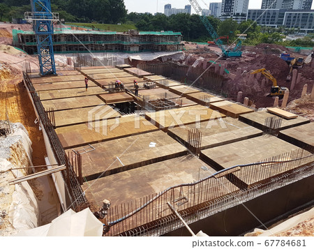 KUALA LUMPUR, MALAYSIA -MARCH 3, 2020: Building floor slab under construction. Construction workers fabricating the timber formwork and installing the steel reinforcement bar. KUALA LUMPUR, MALAYSIA -MARCH 3, 2020: Building floor slab under construction. Construction workers fabricating the timber formwork and installing the steel reinforcement bar. 67784681
