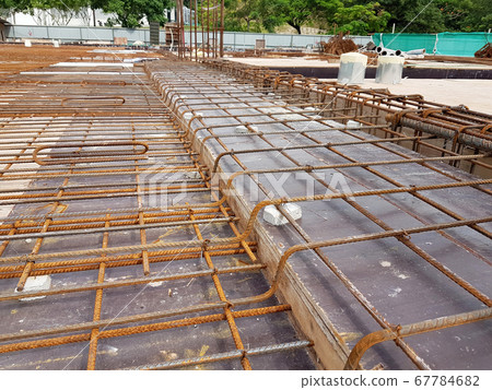 KUALA LUMPUR, MALAYSIA -MARCH 3, 2020: Building floor slab under construction. Construction workers fabricating the timber formwork and installing the steel reinforcement bar. KUALA LUMPUR, MALAYSIA -MARCH 3, 2020: Building floor slab under construction. Construction workers fabricating the timber formwork and installing the steel reinforcement bar. 67784682