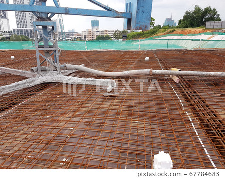 KUALA LUMPUR, MALAYSIA -MARCH 3, 2020: Building floor slab under construction. Construction workers fabricating the timber formwork and installing the steel reinforcement bar. KUALA LUMPUR, MALAYSIA -MARCH 3, 2020: Building floor slab under construction. Construction workers fabricating the timber formwork and installing the steel reinforcement bar. 67784683