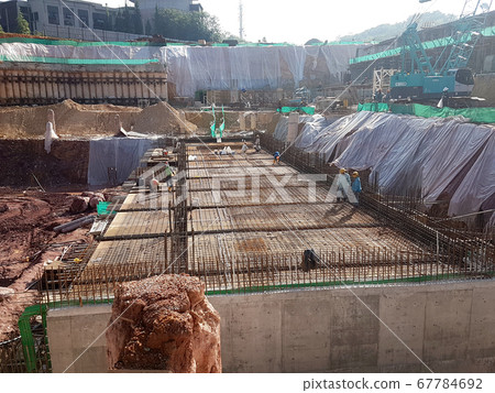 KUALA LUMPUR, MALAYSIA -MARCH 3, 2020: Building floor slab under construction. Construction workers fabricating the timber formwork and installing the steel reinforcement bar. KUALA LUMPUR, MALAYSIA -MARCH 3, 2020: Building floor slab under construction. Construction workers fabricating the timber formwork and installing the steel reinforcement bar. 67784692