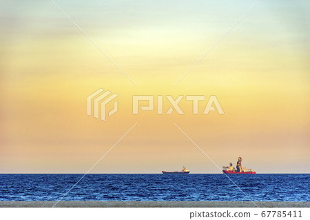 Ships on the horizon during sunset Ships on the horizon during sunset 67785411