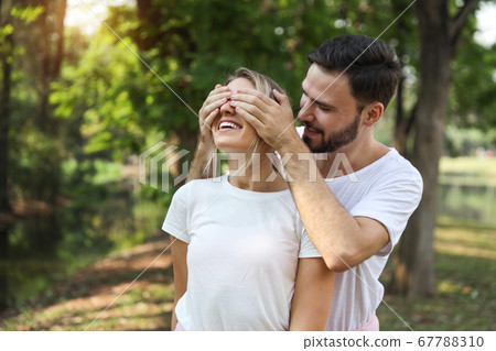 young lovely couple caucasian in white dress playing blindfolded with happy face and laughing 67788310