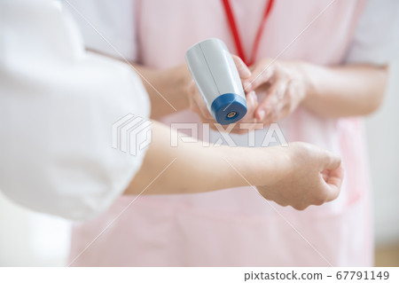 用非接觸式溫度計測量溫度的醫療護士（手） 67791149